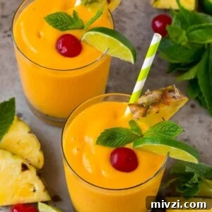 Tropical smoothies garnished with mint, limes and pineapple.