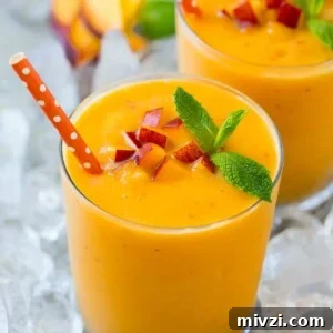 A peach smoothie in ice garnished with mint.