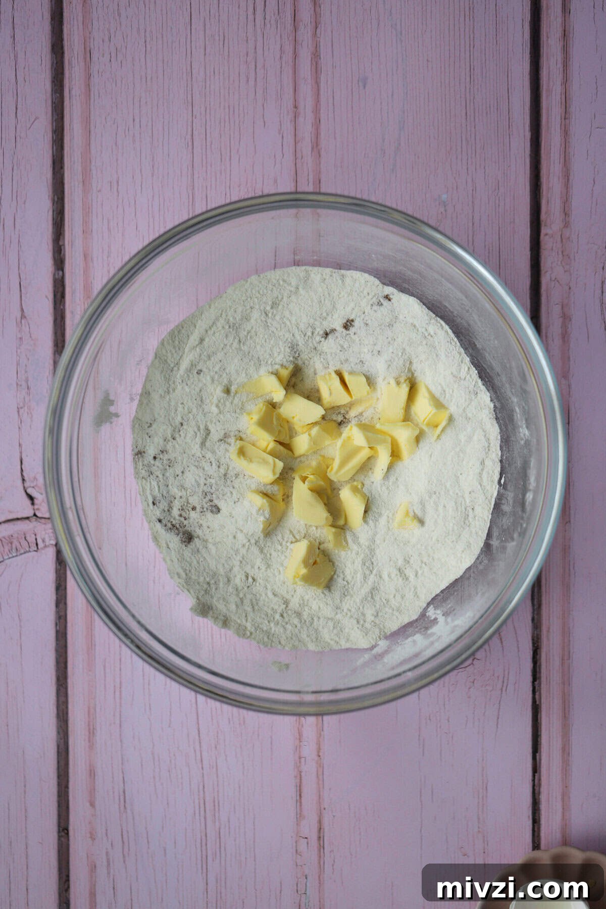 Add the cubed butter to the dry ingredients.