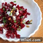 A dish of quick pickled beets tossed with goat cheese, chives and pepitas.