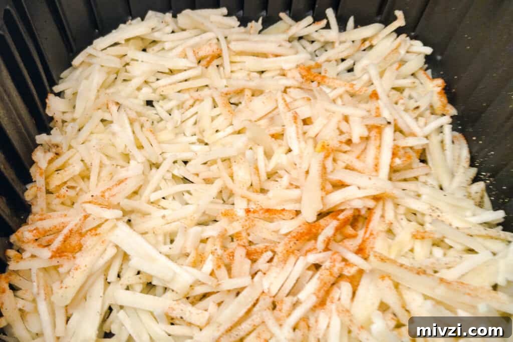 Crispy Air Fryer Hash Browns in 15 Minutes 4 Frozen hash browns in air fryer basket seasoned up and ready to cook.