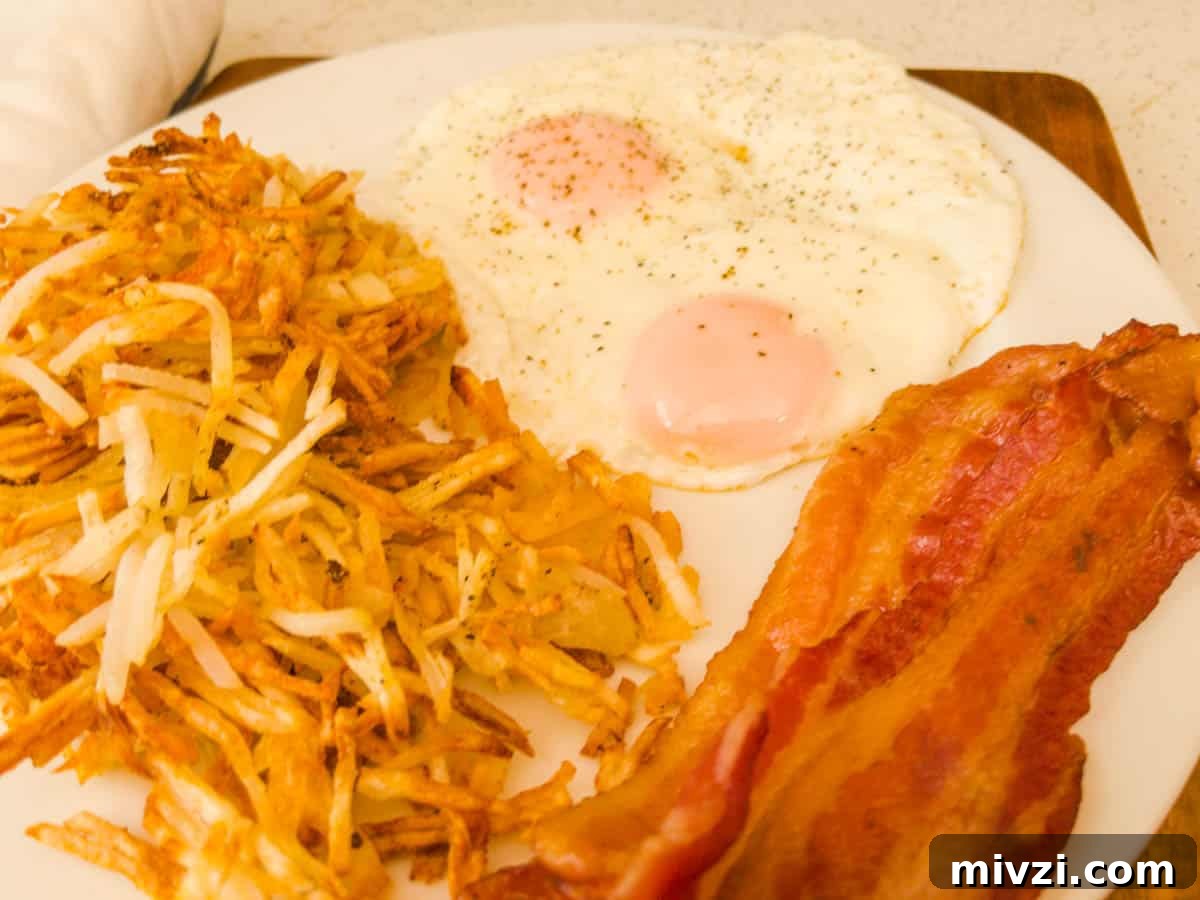 Crispy Air Fryer Hash Browns in 15 Minutes 6 Hash browns eggs and bacon on a plate for breakfast