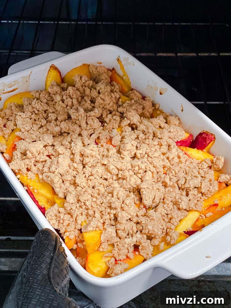 process shot showing butter topping added to baking dish of peaches