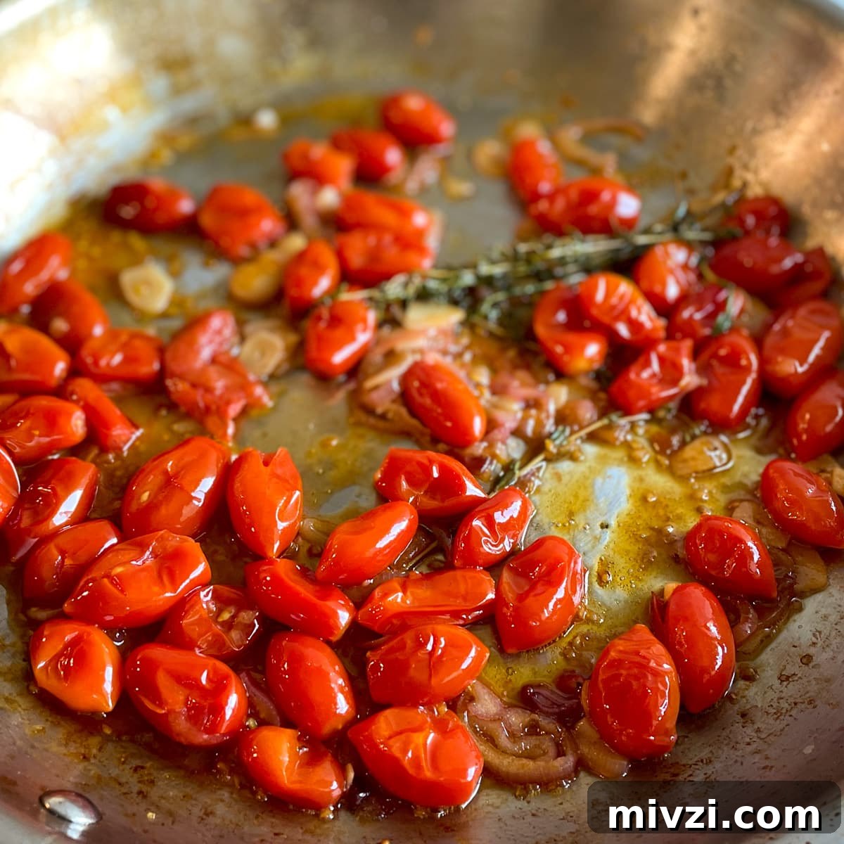 Burst cherry tomatoes with sliced shallots, garlic, white wine, lemon juice, olive oil, and springs of thyme in a stainless steel pan