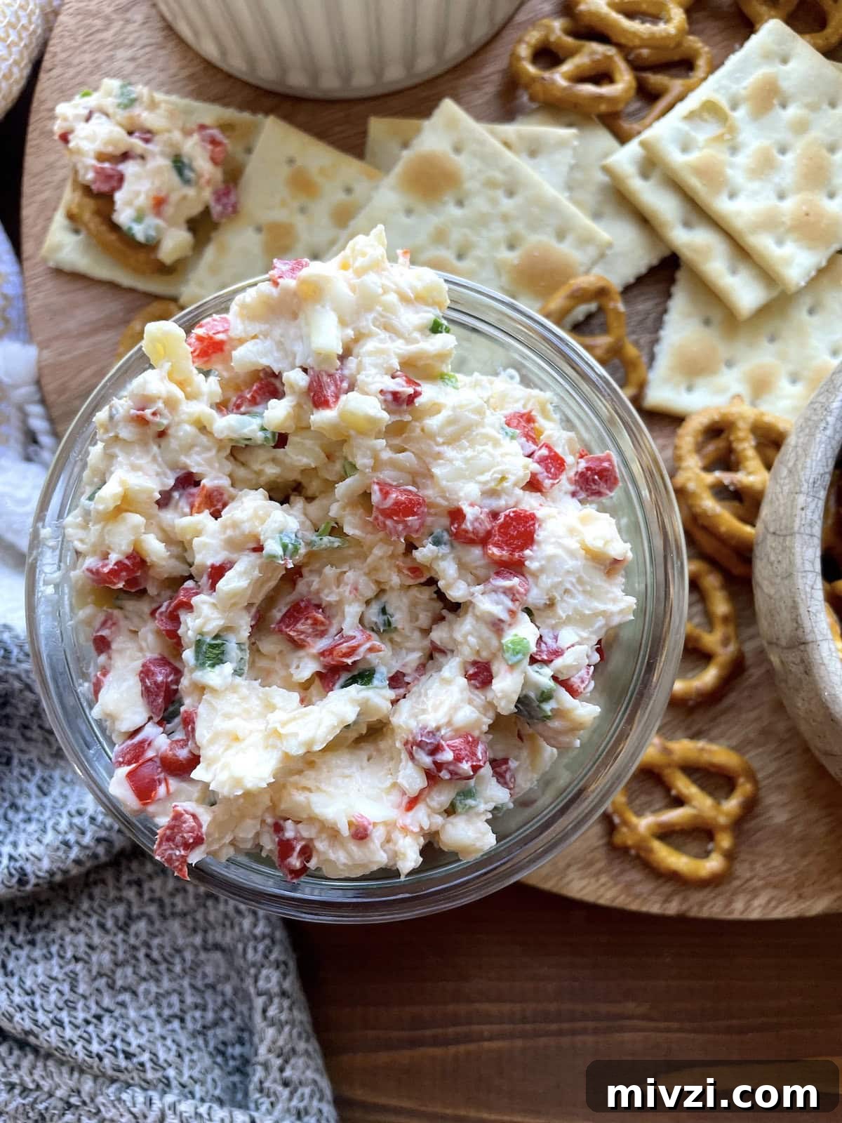 Spicy Jalapeño Pimento Cheese Dip Recipe 2 A bowl of spicy pimento cheese surrounded by saltines and pretzels.