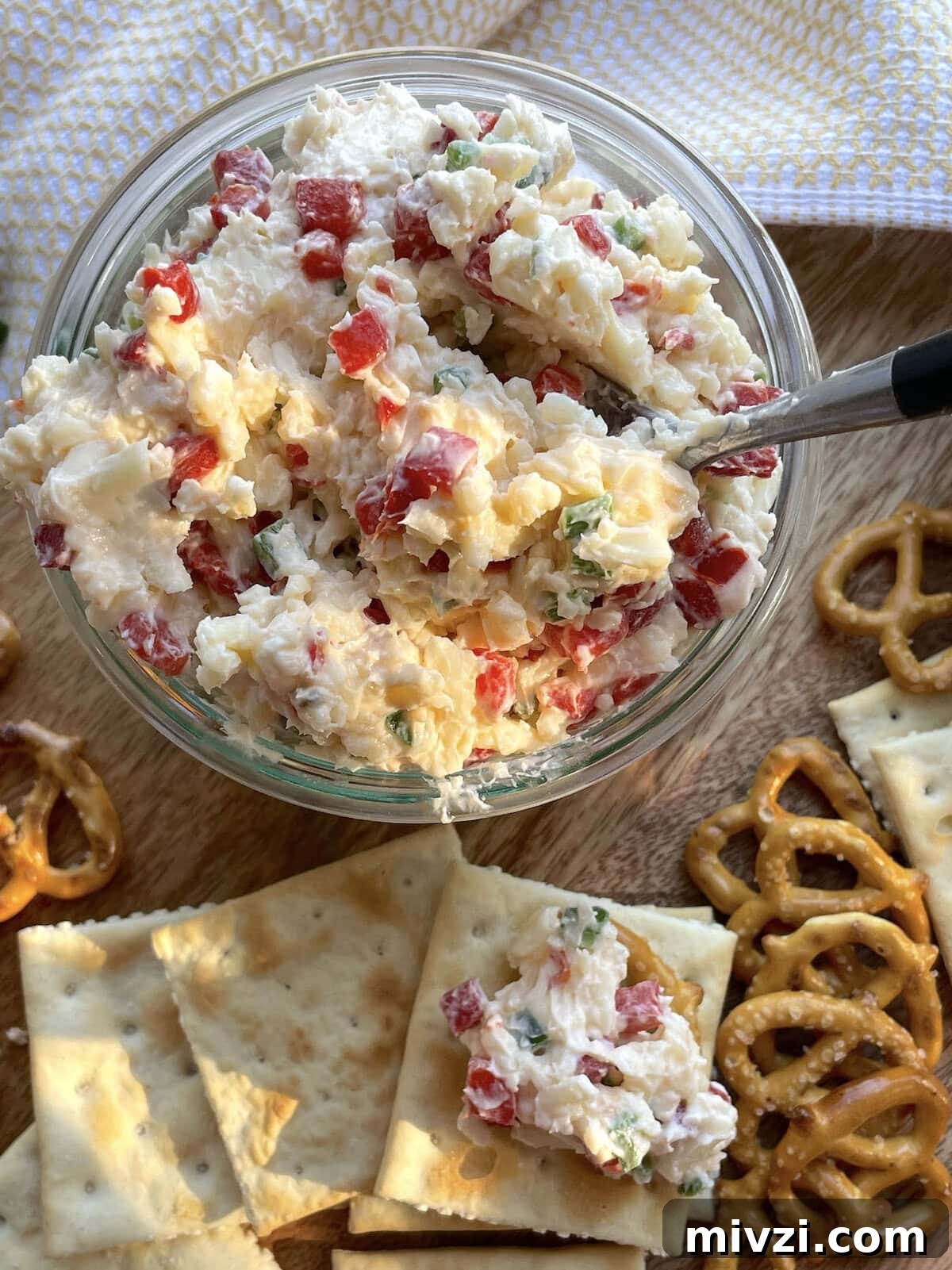 Spicy Jalapeño Pimento Cheese Dip Recipe 9 A jar of spicy pimento cheese surrounded by saltines and pretzels.