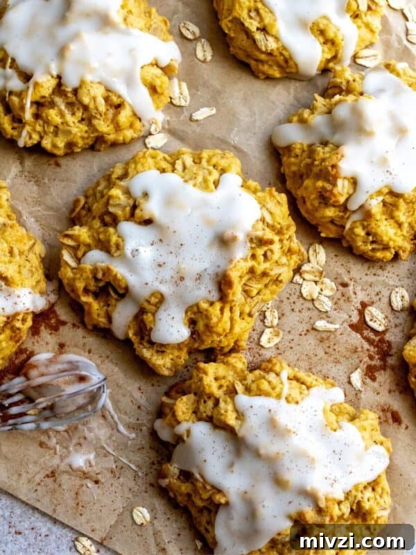 Pumpkin Pie Cookies on parchment paper with oats on the side.