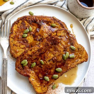 A slice of pumpkin french toast on a plate topped with pumpkin seeds.