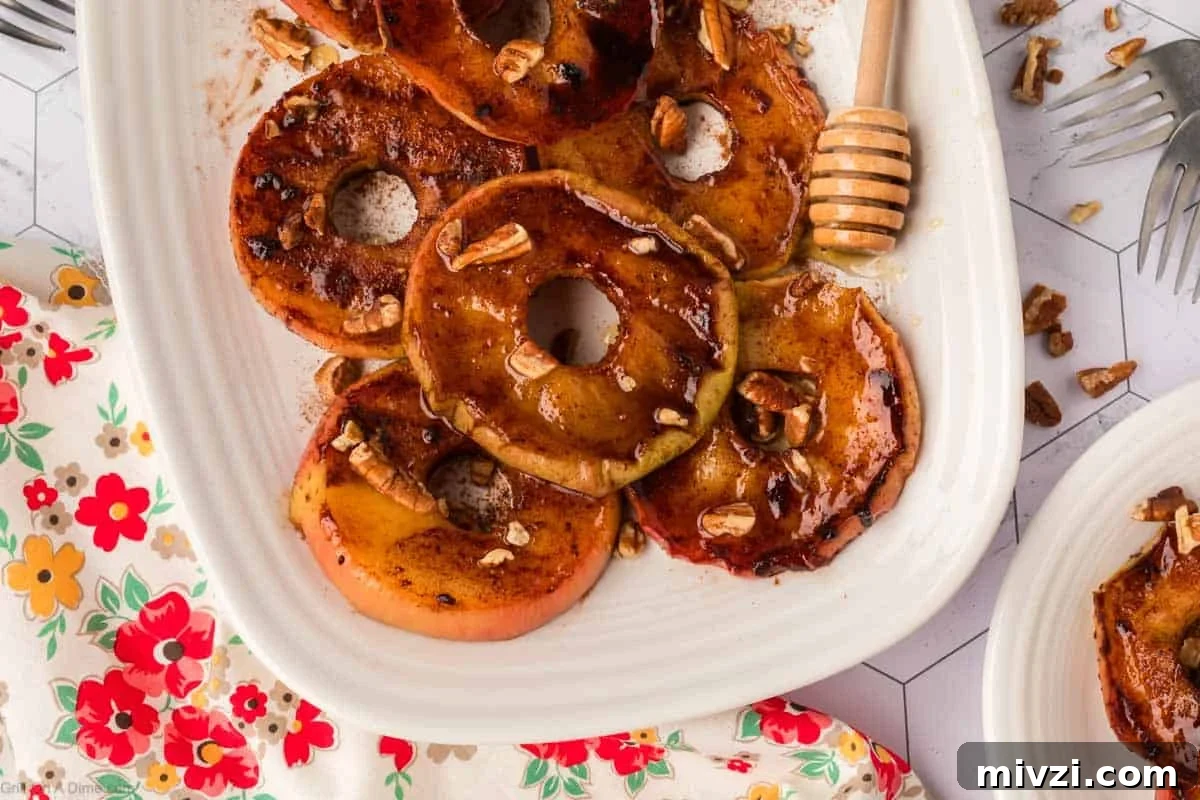 Caramelized Grilled Apples with Cinnamon and Honey 2 Grilled Slice Apples on a white platter topped with chopped nuts