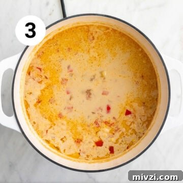 Cooked vegan potato and corn chowder in a large pot, ready for blending.