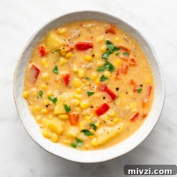 Vegan potato and corn chowder served in a bowl with parsley on top.