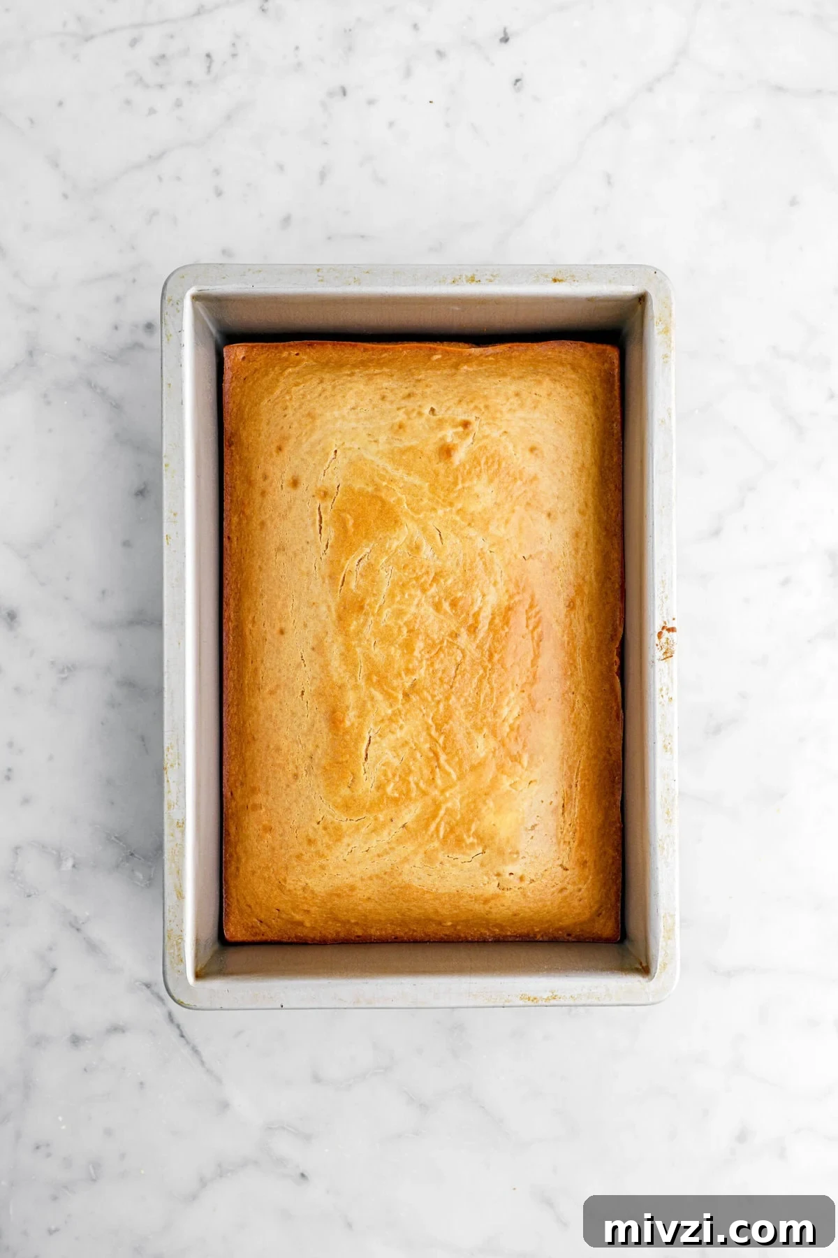 baked sheet cake in pan on marble surface.