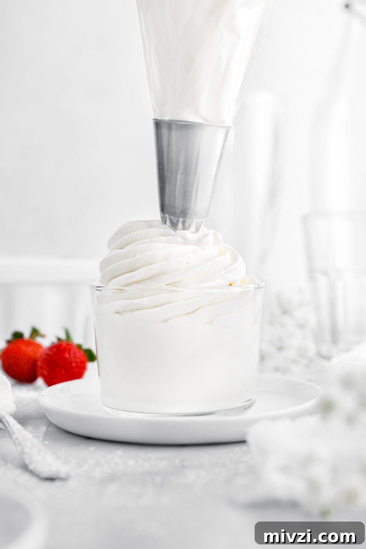 chantilly cream being piped into glass.