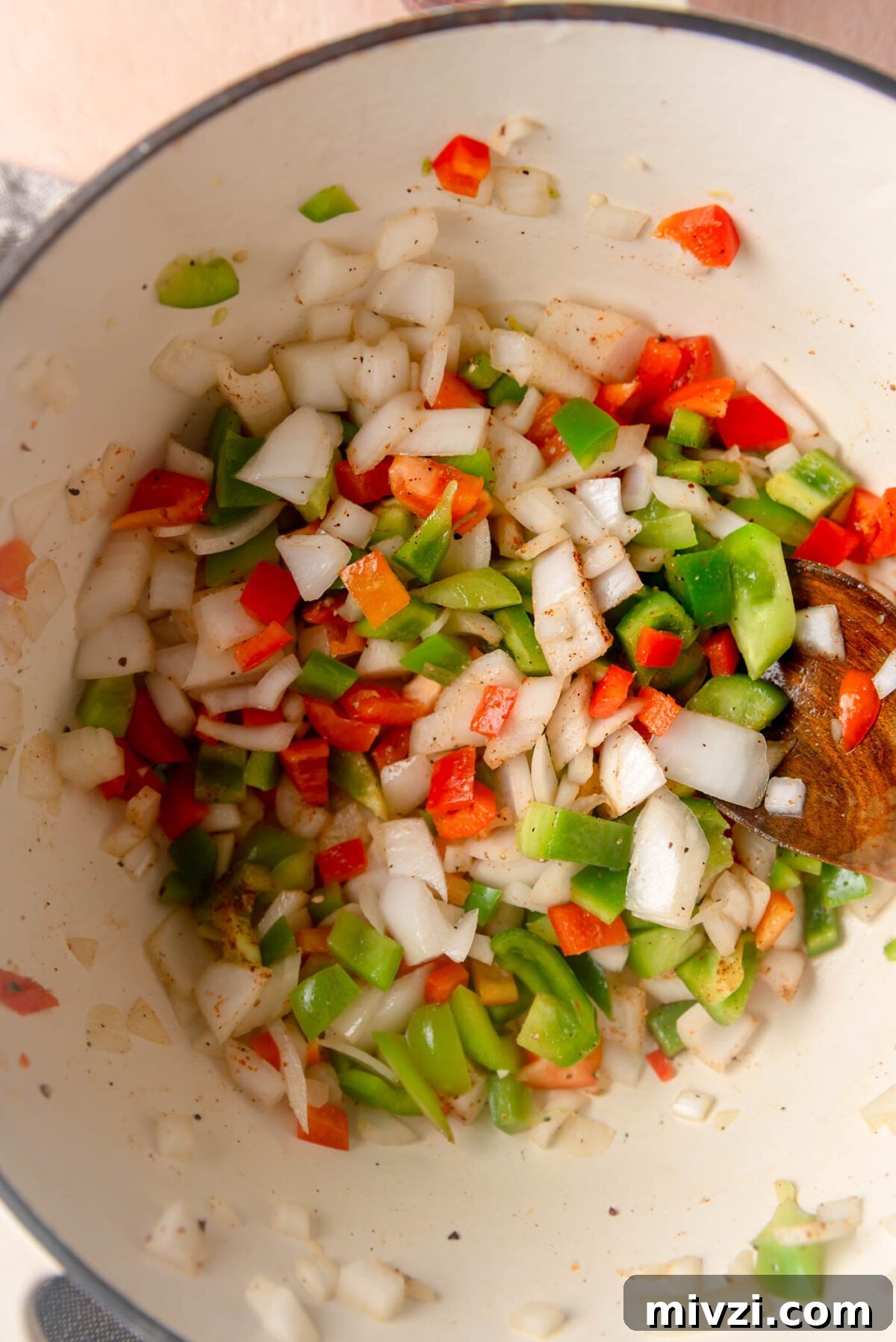 Hearty Vegan Enchilada Soup with Black Beans and Corn 5 Diced onion and bell peppers cooking in spices in a large pot.