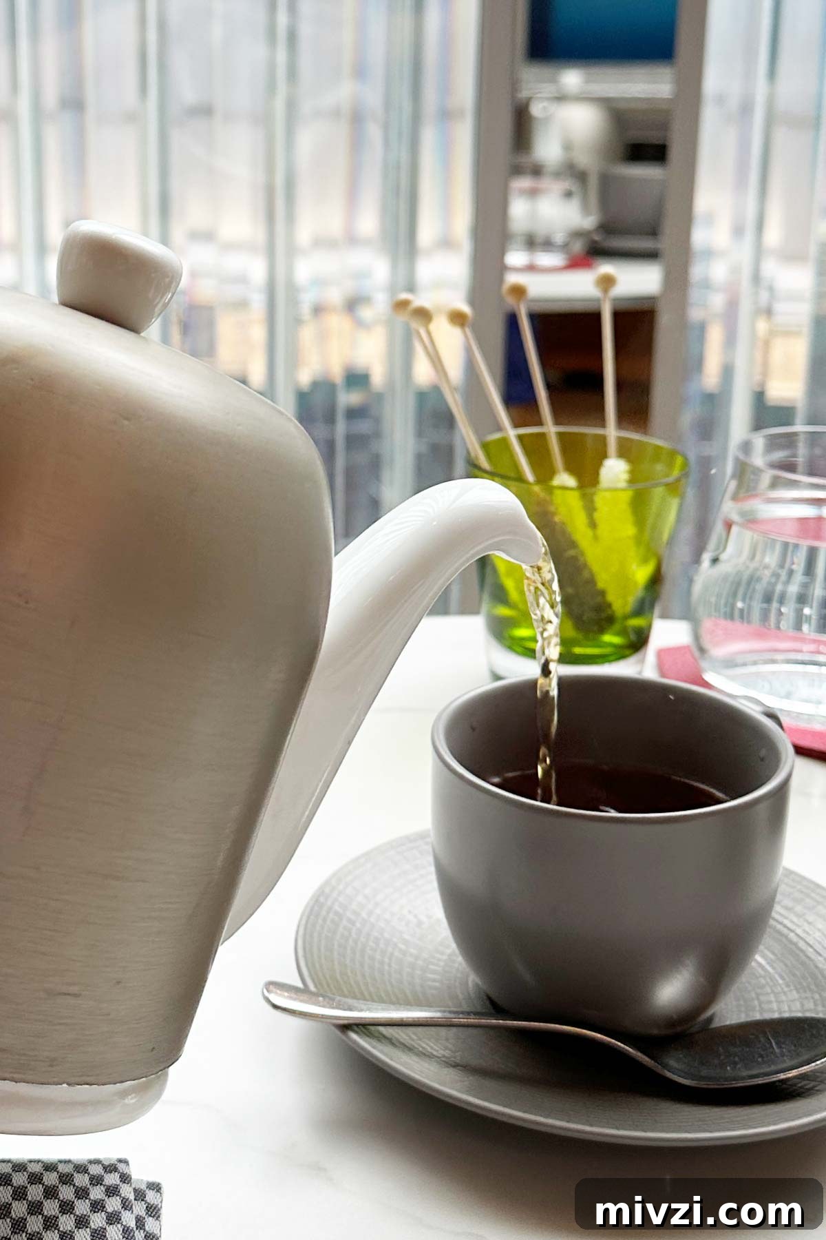 Afternoon Tea at Baccarat Hotel New York: A Luxurious Review 5 Pouring tea from a teapot into a tea cup.