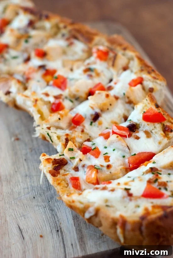 Garlic Bread Pizza with Chicken and Crispy Bacon 6 Split apart Garlic Bread Pizza with fresh tomatoes, mozzarella on a wooden board.