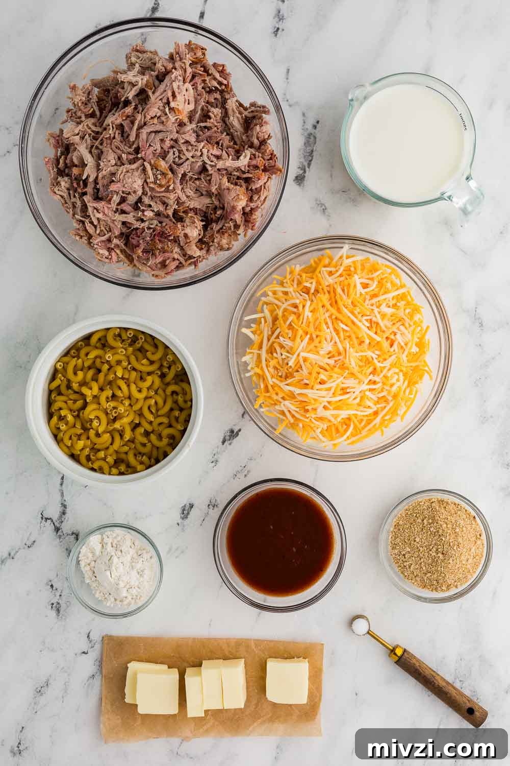 Pulled Pork Mac and Cheese Recipe — Slow-Cooked BBQ Comfort Dish 3 bowl of pulled pork, measuring cup of milk, bowl of shredded cheese, bowl of dried elbow noodles, bowl of breadcrumbs, bowl of bbq sauce, ramekin of flour and cut pats of butter