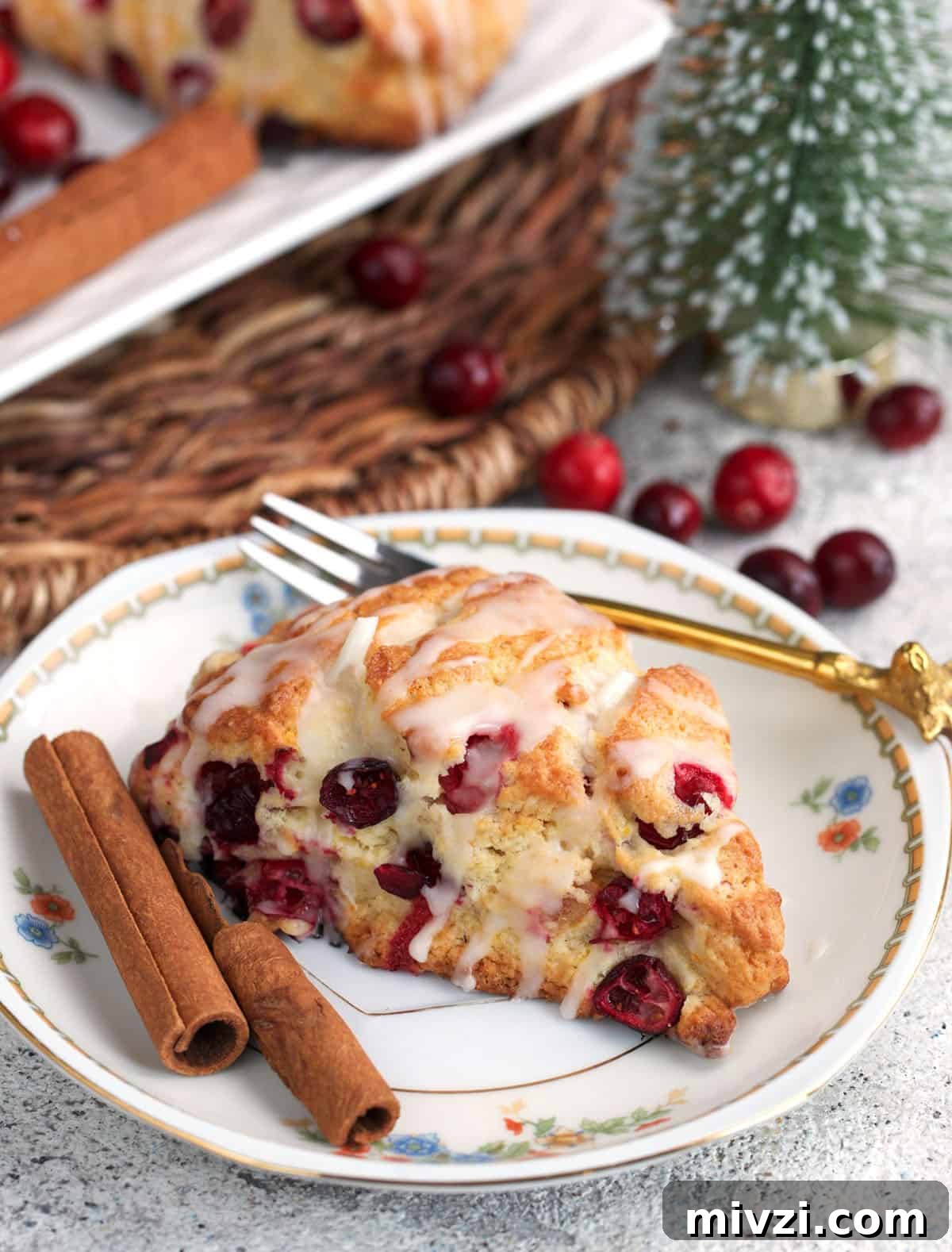 Cranberry Orange Scones on a plate with a gold fork and fresh cranberries.