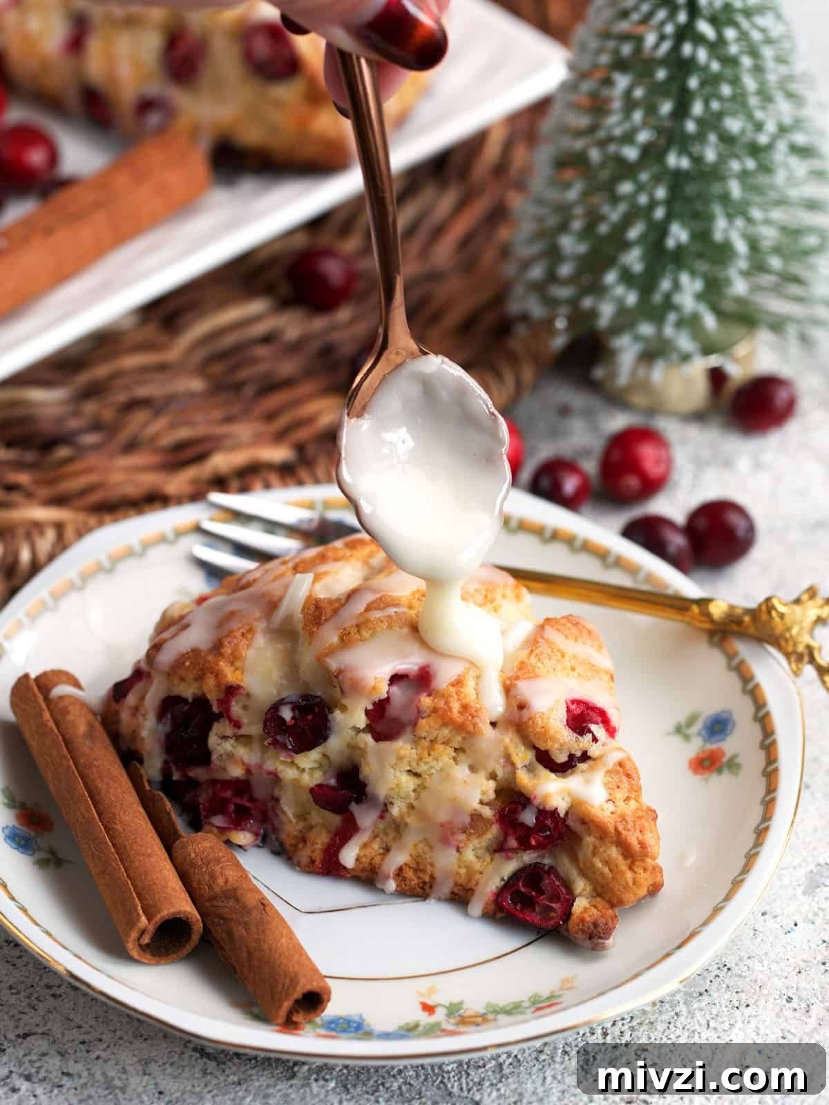 Cranberry Orange Scone being drizzled with orange glaze.