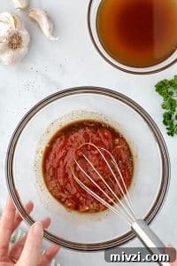 Whisking together ketchup and sauce ingredients.