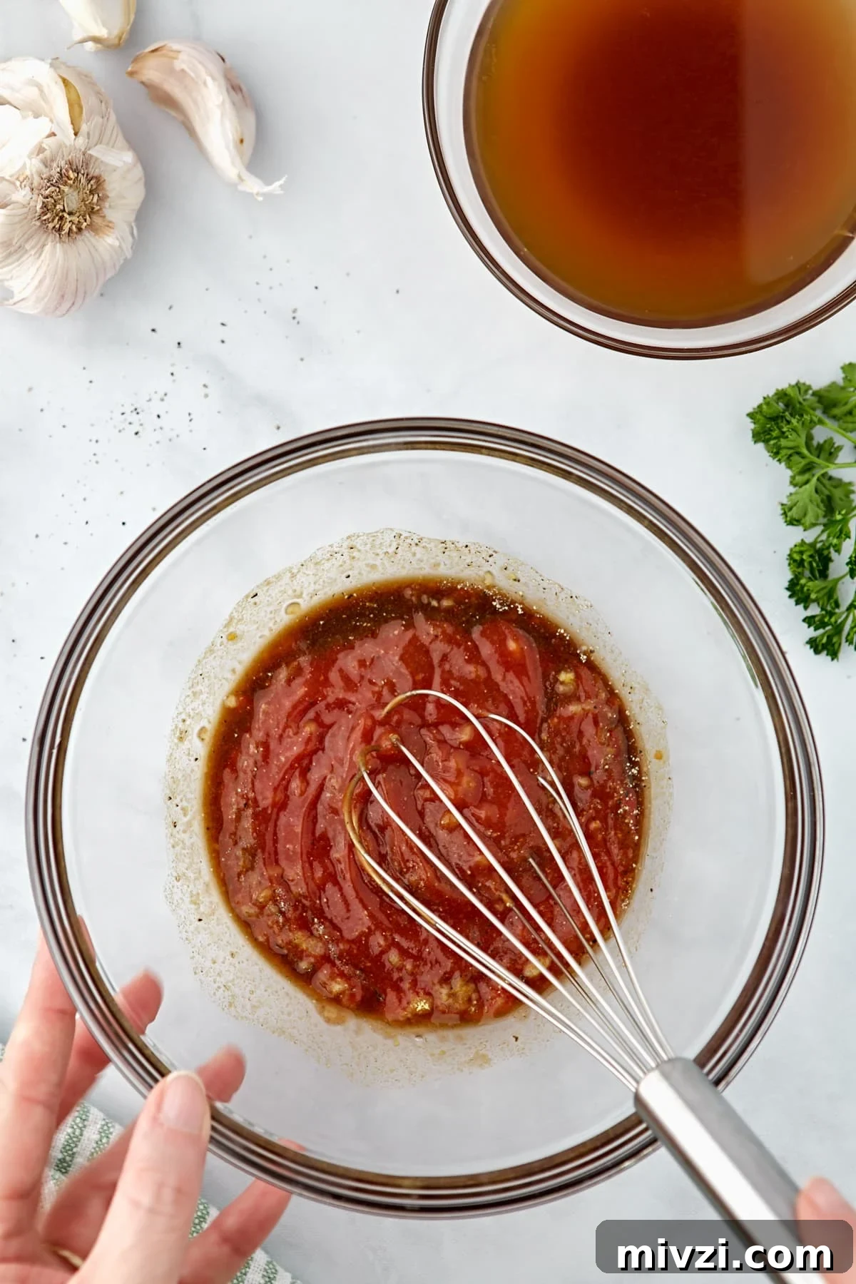 Whisking together ketchup and sauce ingredients.