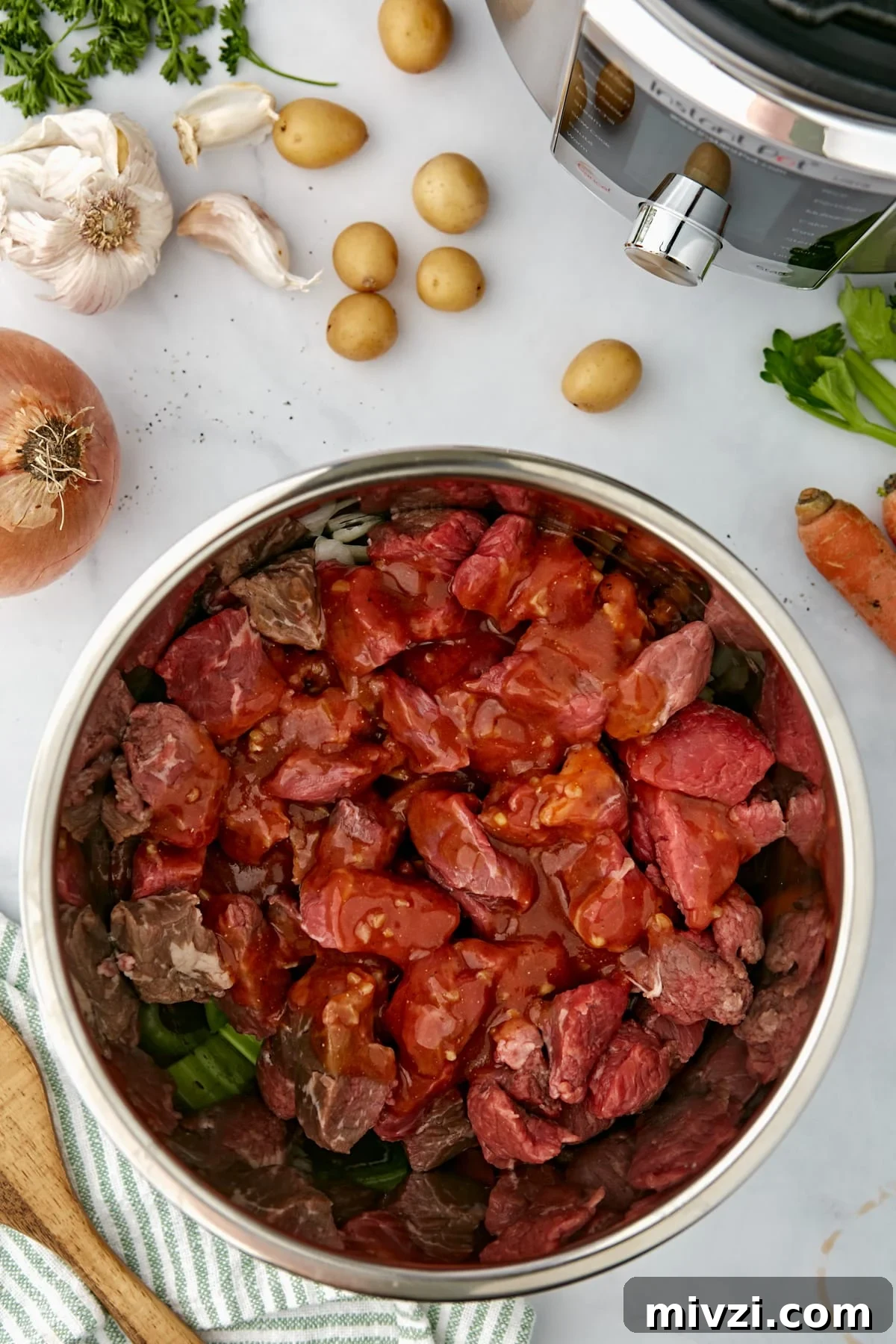 An Instant Pot filled with beef cubes and a sauce mixture.