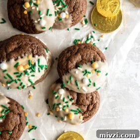 bailey's irish cream cookies with icing and sprinkles on parchment paper with some gold coins.