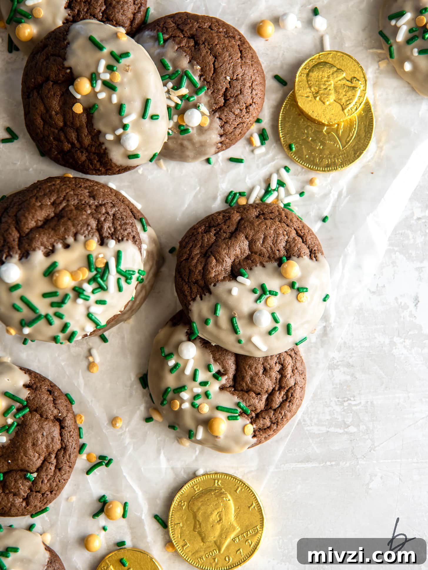 bailey's irish cream cookies with icing and sprinkles on parchment paper with some gold coins.