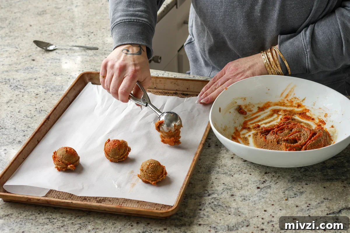 scooping gochujang caramel cookies onto the cookie sheet