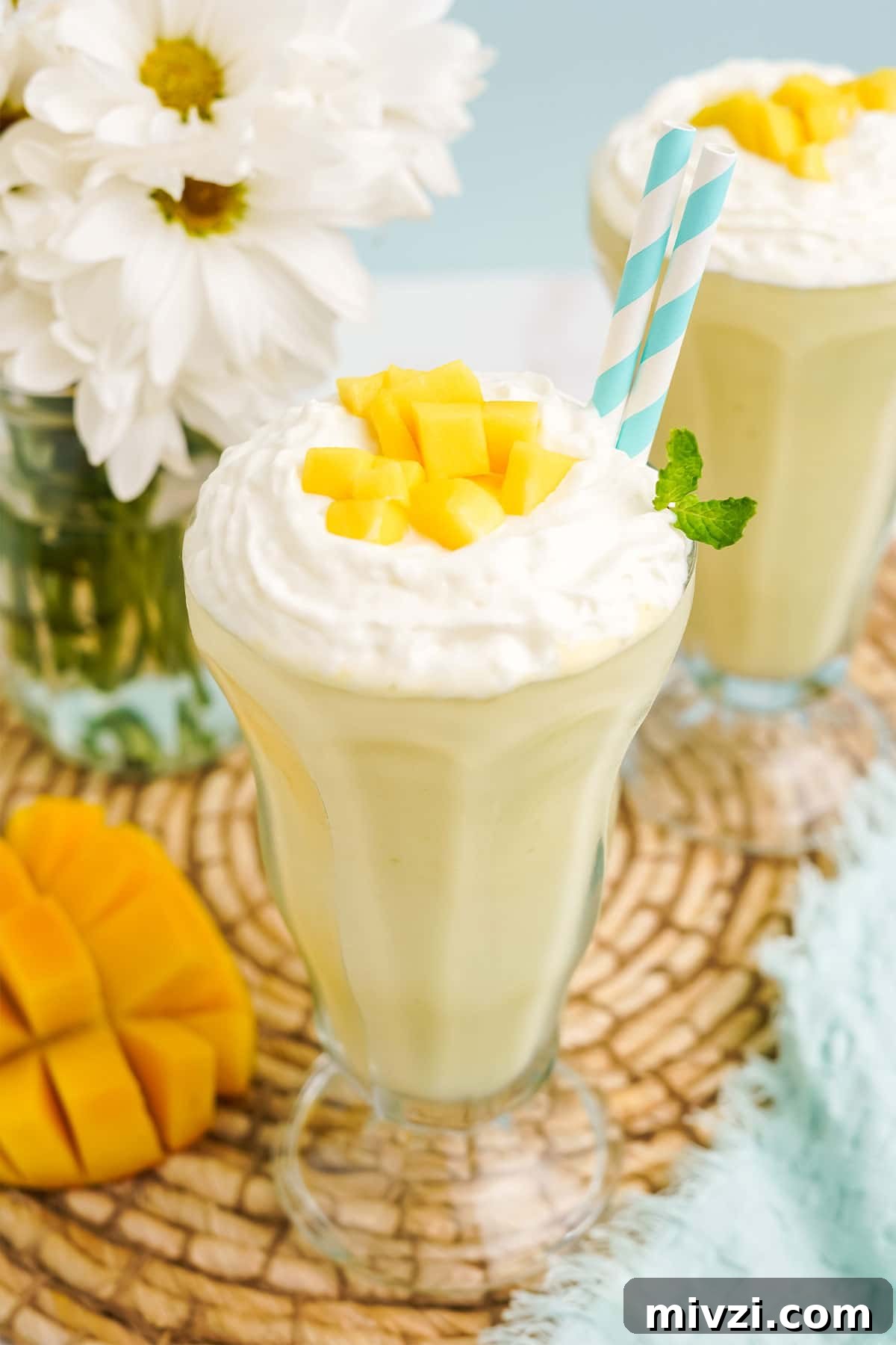 Close up of mango milkshake in a old-fashioned soda glass.