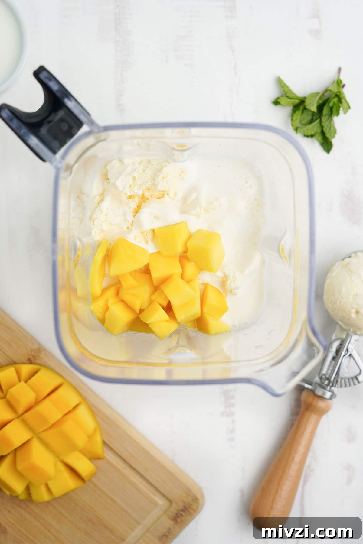 Ingredients for a mango shake in the blender.