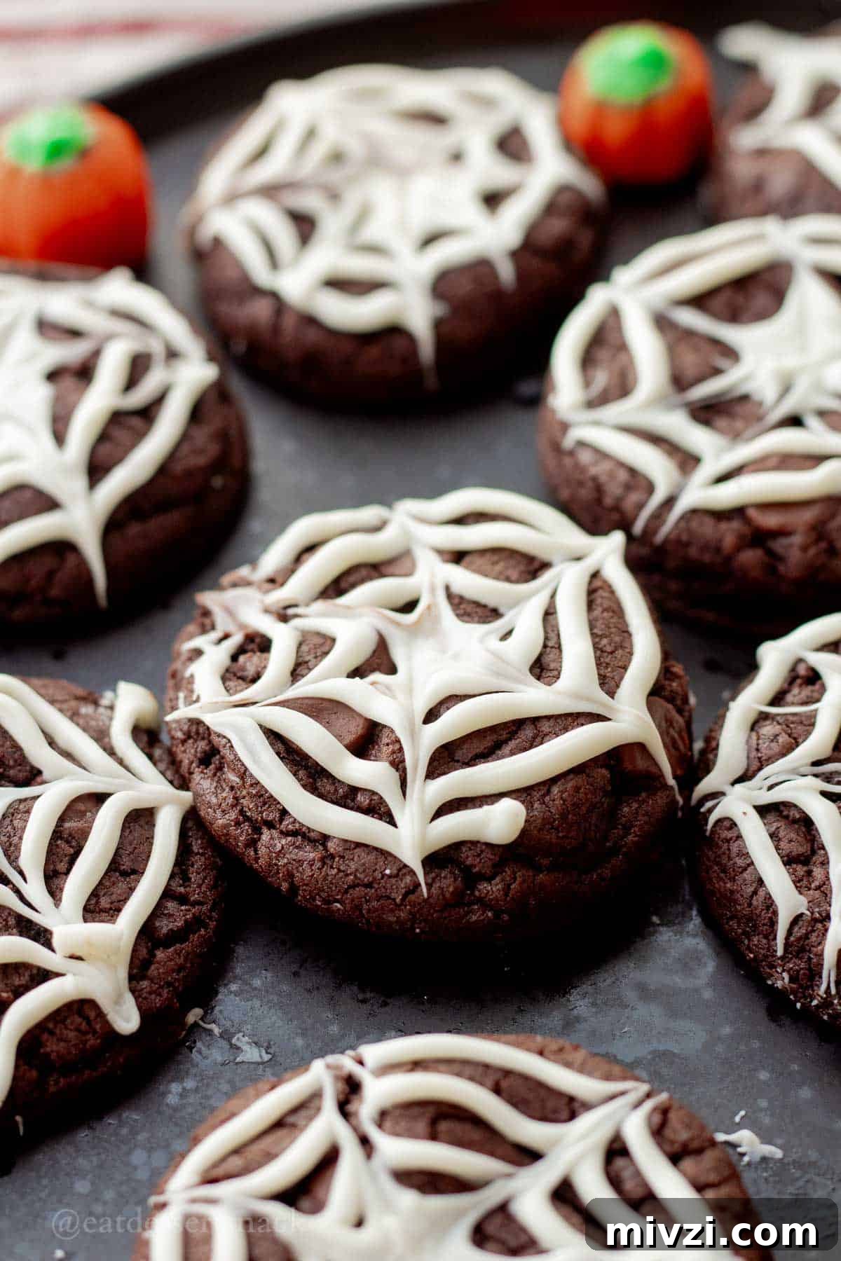Spider Web Halloween Cookies: Step-by-Step Recipe & Decorating Tips 2 Baked chocolate spider web cookies on black plate.