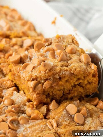 Slice of butterscotch pumpkin cake in pan with spatula.