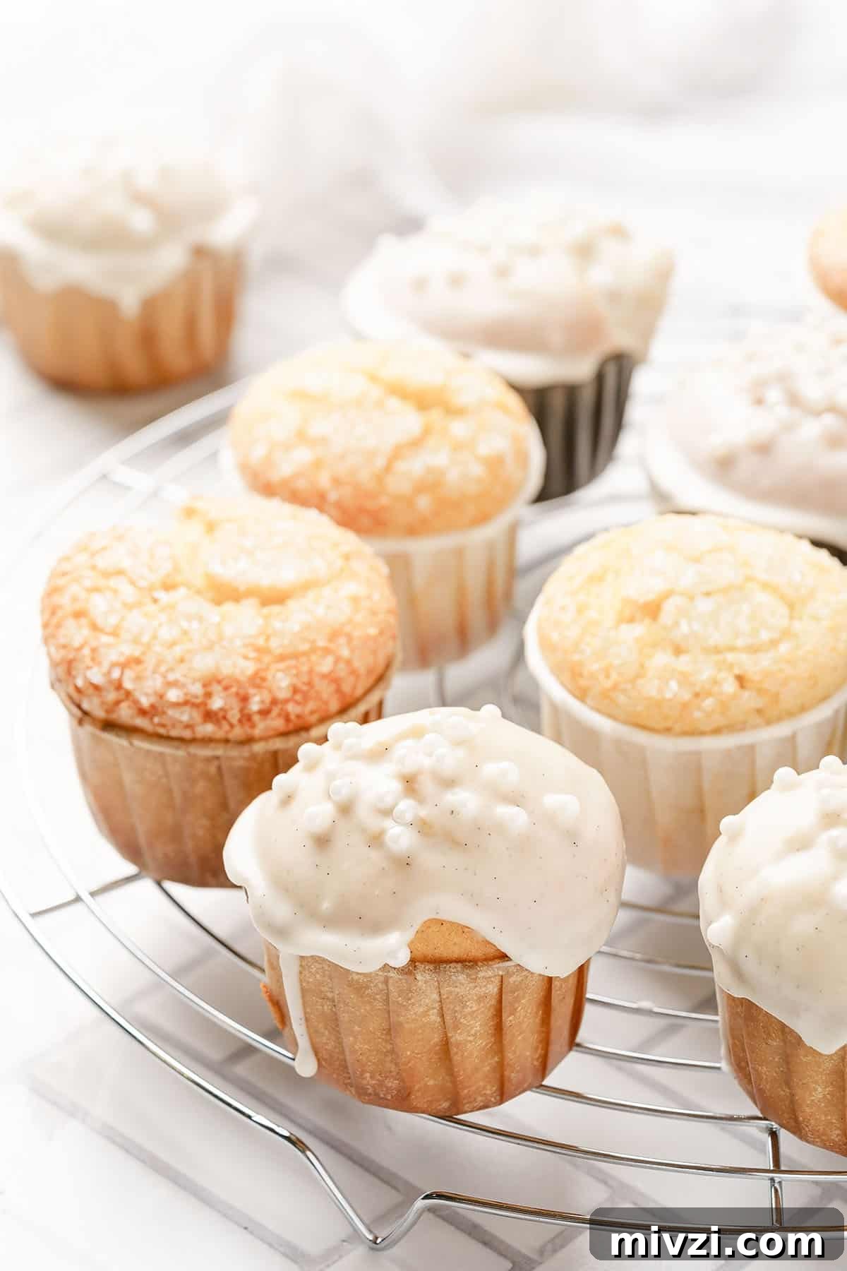 Classic Vanilla Muffins Recipe: Light, Fluffy & Quick 2 vanilla muffins on wire rack.