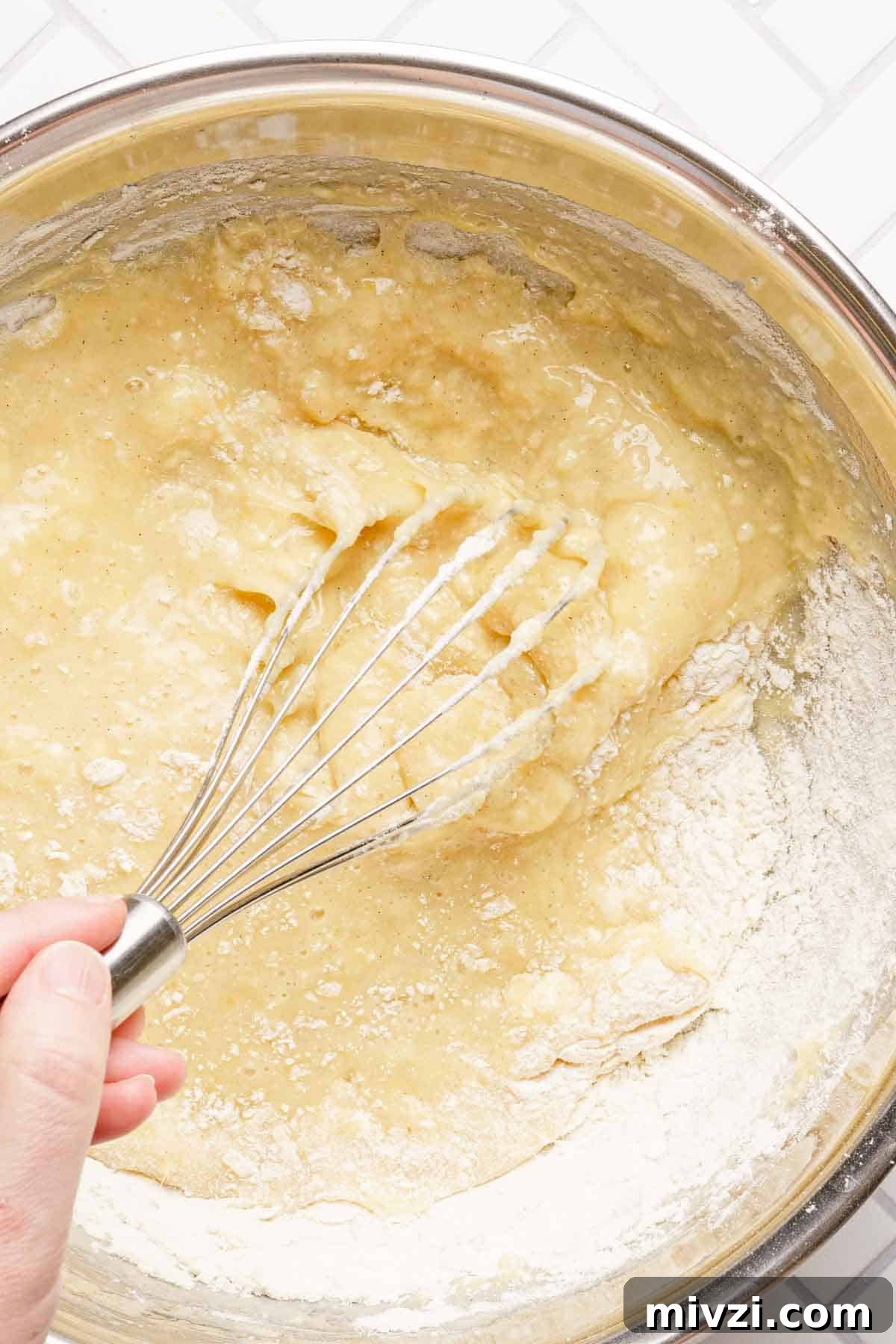 Classic Vanilla Muffins Recipe: Light, Fluffy & Quick 11 flour being whisked into muffin batter.