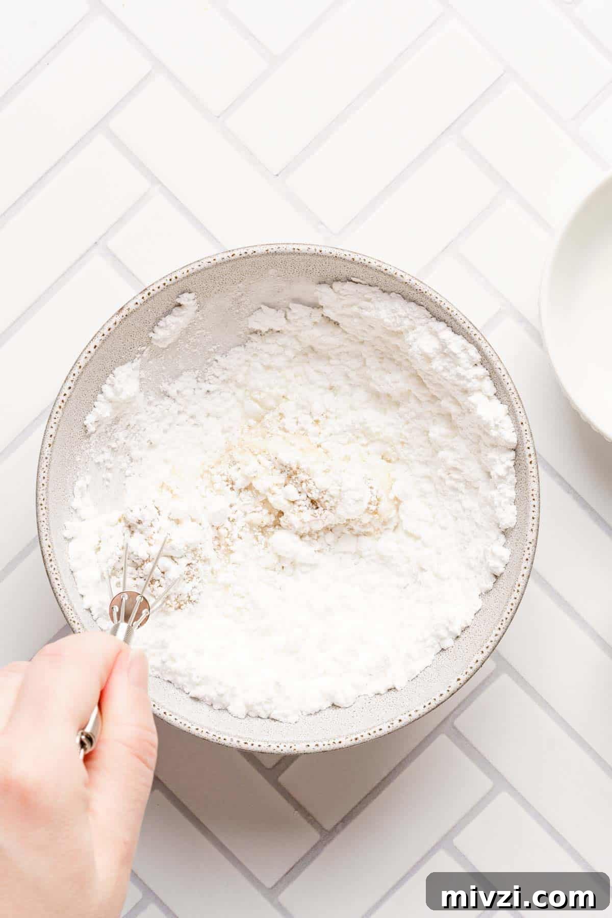 Classic Vanilla Muffins Recipe: Light, Fluffy & Quick 16 muffin glaze being whisked in small bowl.