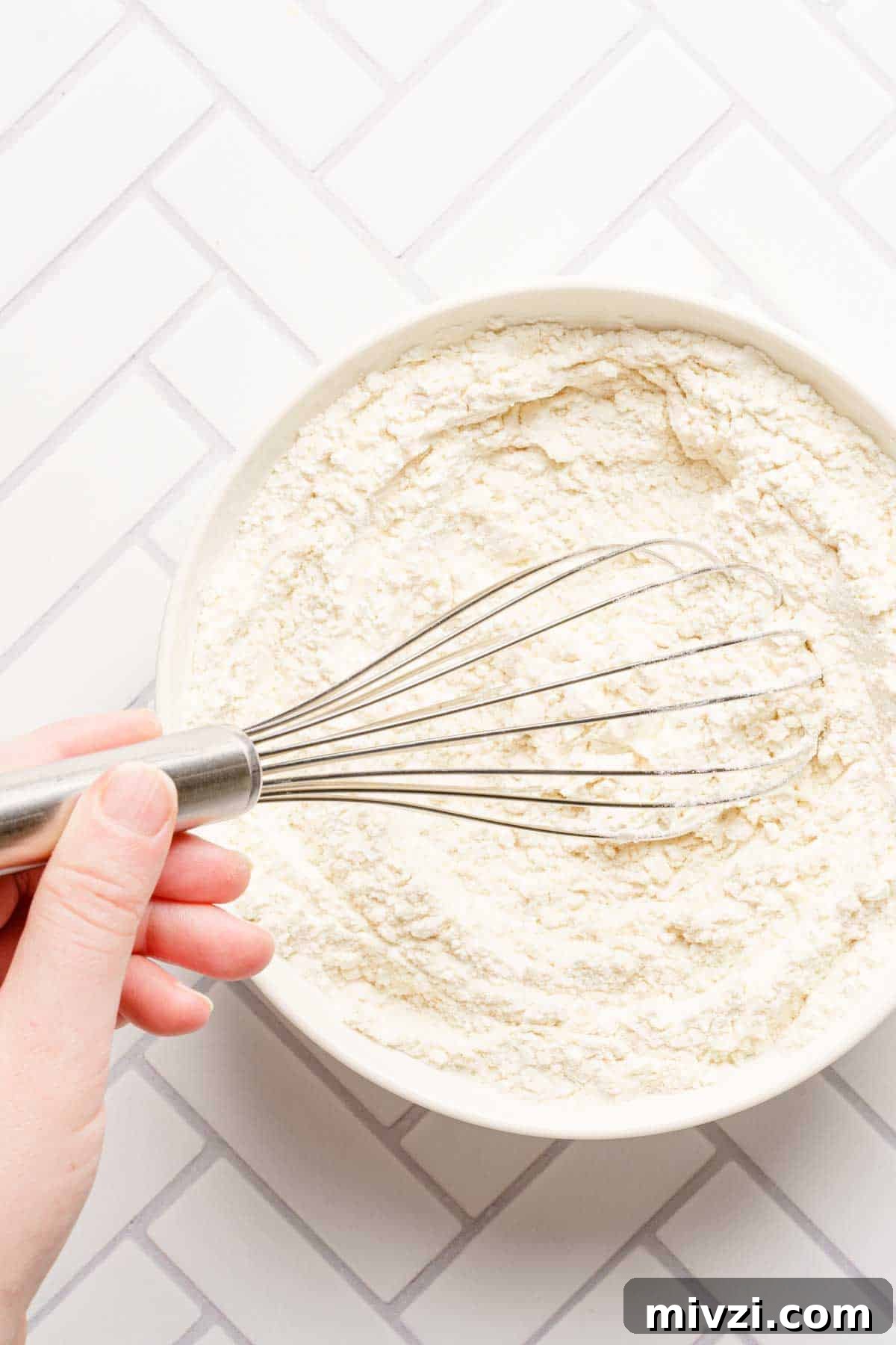 Classic Vanilla Muffins Recipe: Light, Fluffy & Quick 7 dry ingredients being whisked together in medium bowl.