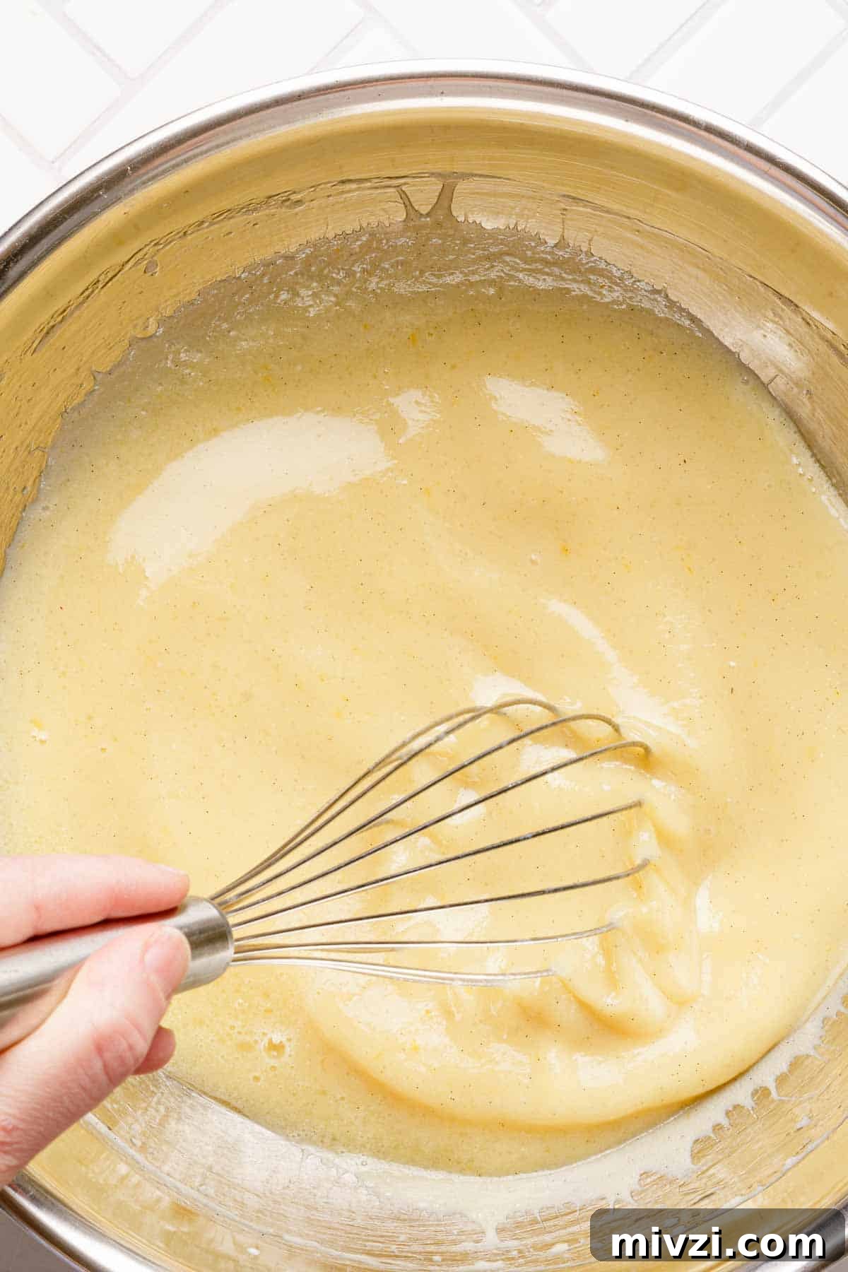 Classic Vanilla Muffins Recipe: Light, Fluffy & Quick 9 wet muffin ingredients being whisked together in bowl.