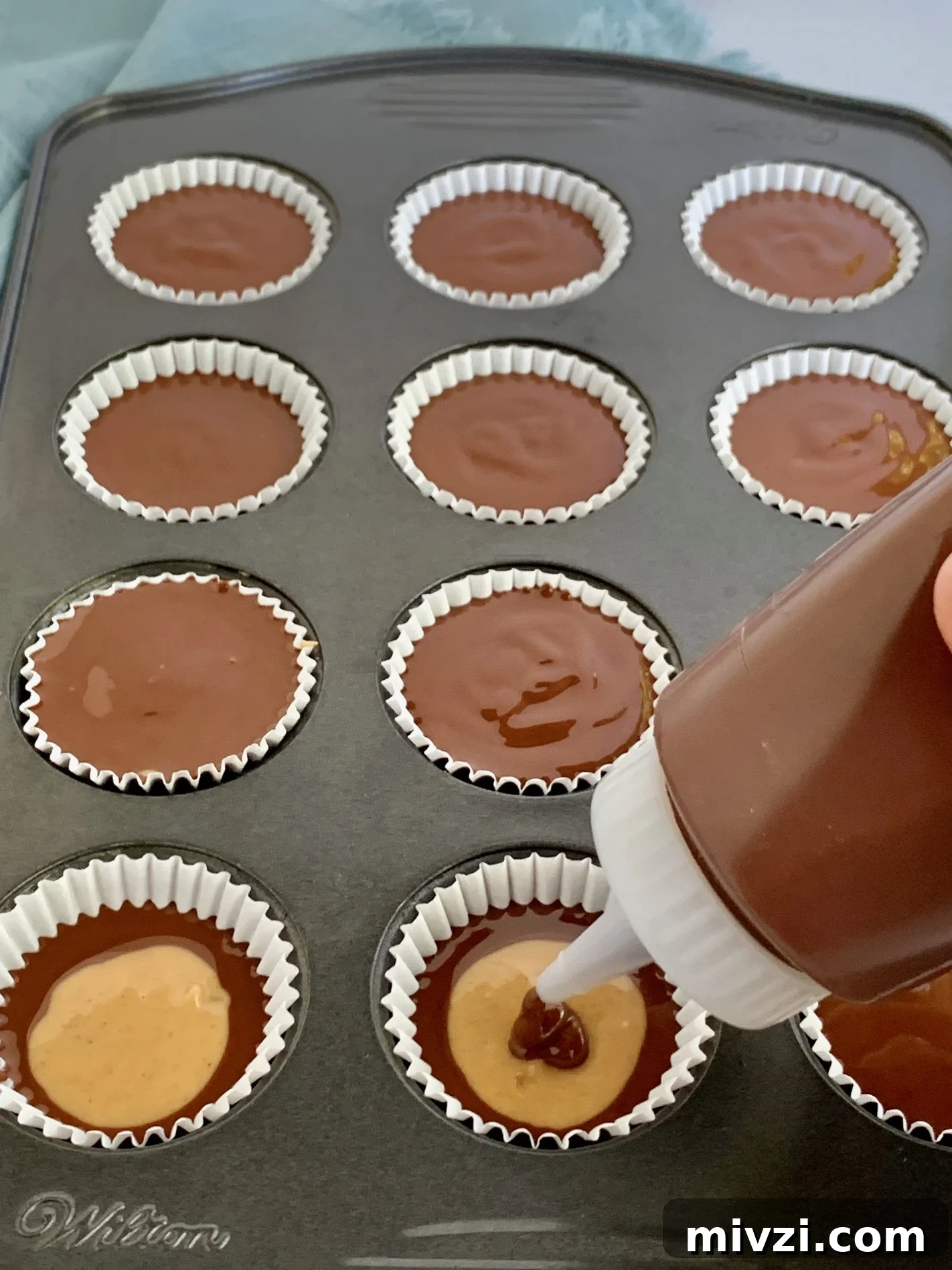 Place the top layer of melted chocolate on the peanut butter cups