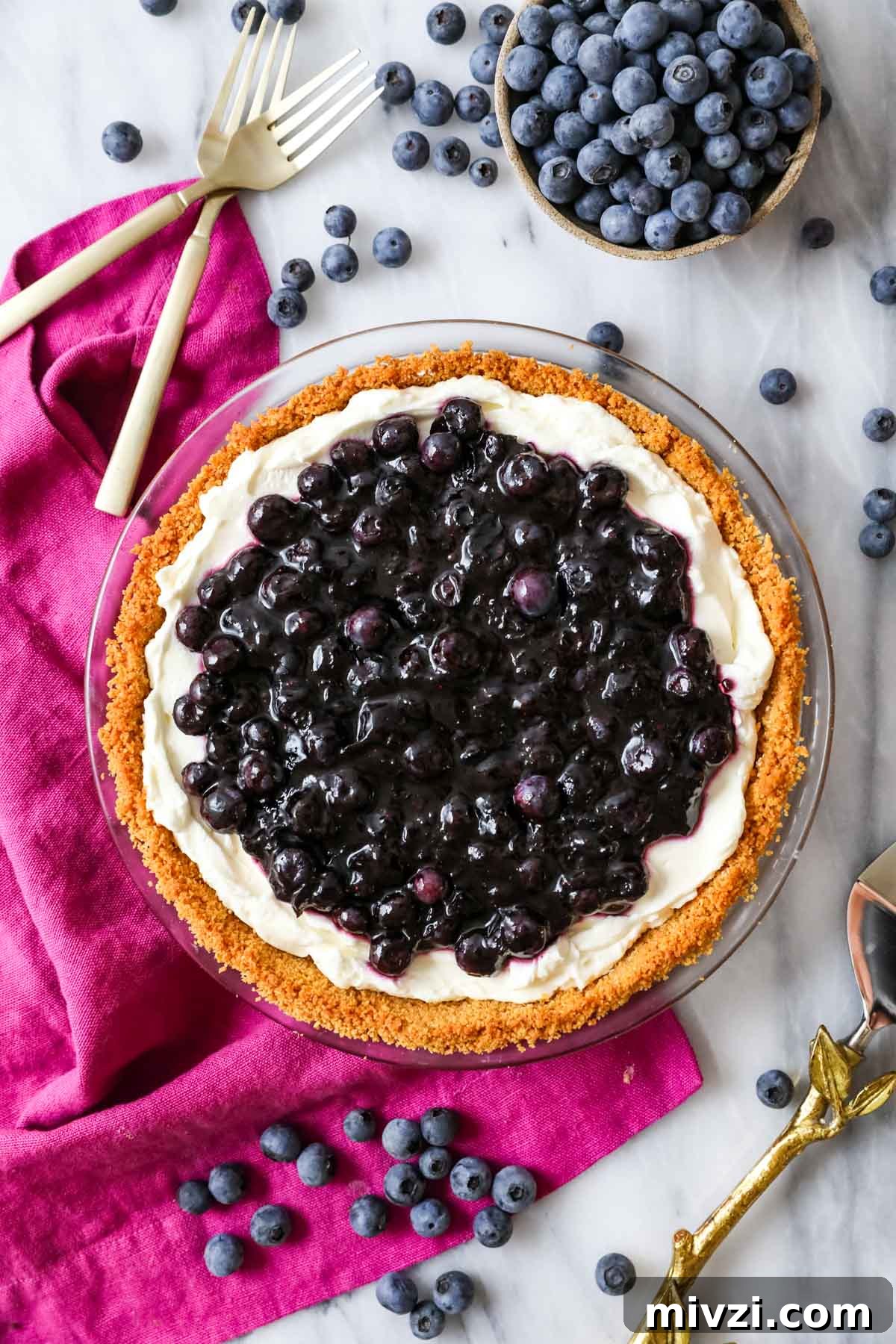 Overhead view of a blueberry cream cheese pie in a graham cracker crust.