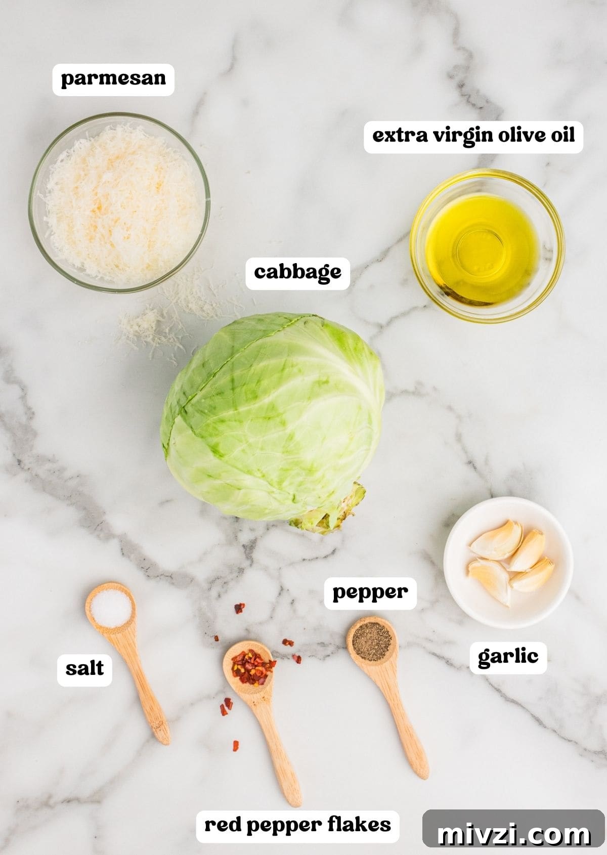 Crispy Roasted Cabbage Wedges with Garlic and Parmesan 4 Ingredients for roasted cabbage wedges on countertop: freshly grated parmesan, extra virgin olive oil, head of green cabbage, salt, pepper, red pepper flakes, and 4 garlic cloves.