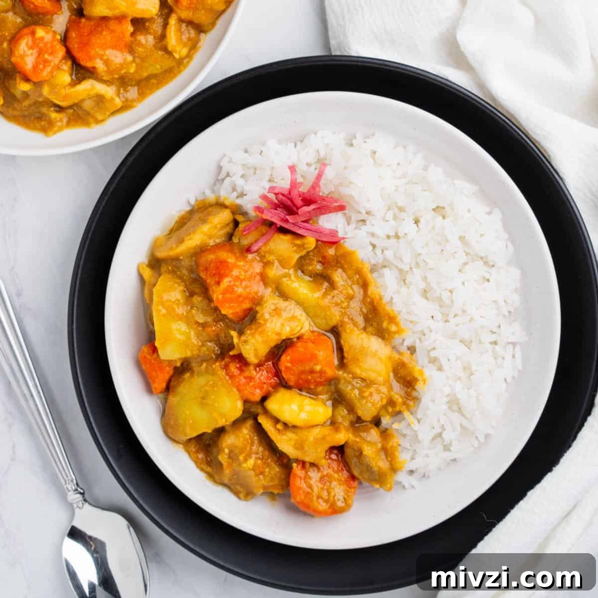 Authentic Japanese Chicken Curry Recipe for Rich, Comforting Flavor 2 Plate of Japanese Chicken Curry with side of white rice.