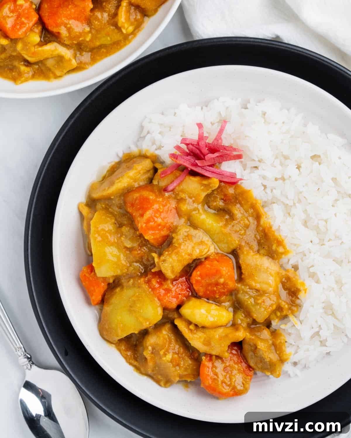Authentic Japanese Chicken Curry Recipe for Rich, Comforting Flavor 7 Plate of Japanese curry on top of rice with pickled ginger.