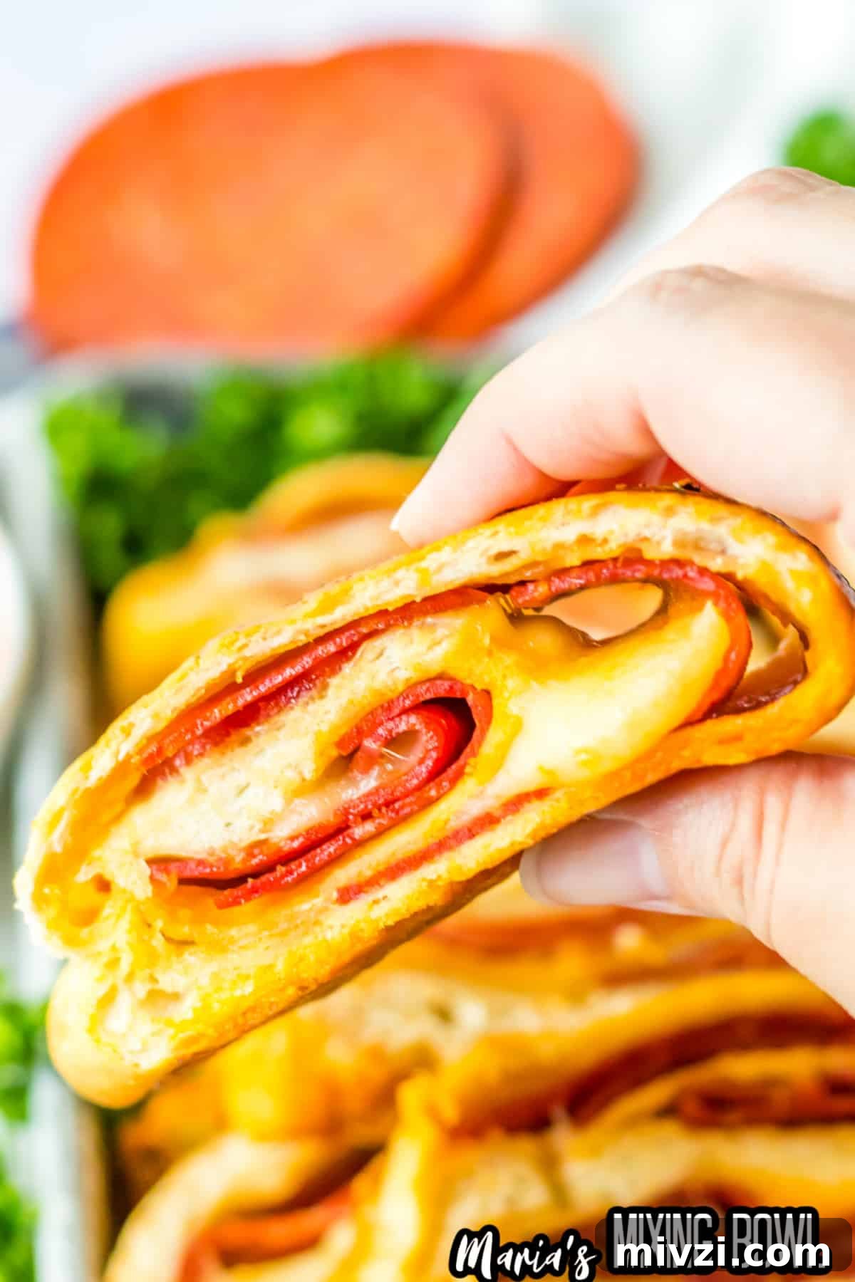 Pepperoni-Stuffed Bread: Cheesy, Savory Pull-Apart Loaf 3 slice of stuffed pepperoni bread held in a womans hand in the air.