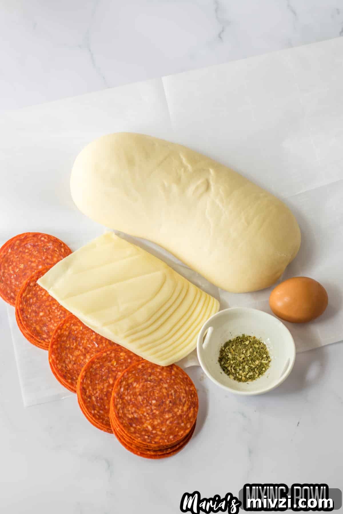 Pepperoni-Stuffed Bread: Cheesy, Savory Pull-Apart Loaf 4 loaf of bread dough, slices of pepperoni, slices of mozzarella cheese, an egg, and a small bowl of italian seasoning.