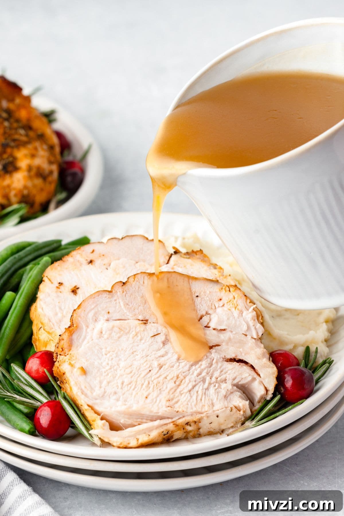 Gravy being poured over boneless turkey breast.