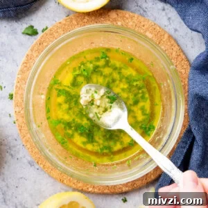 bowl filled with fresh, homemade garlic butter sauce with a spoon