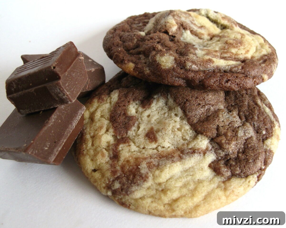 Marble Cookies Recipe: Soft Swirls of Chocolate and Vanilla 9 Marbled Chocolate Chunk Cookies on a white background with chunks of chocolate.