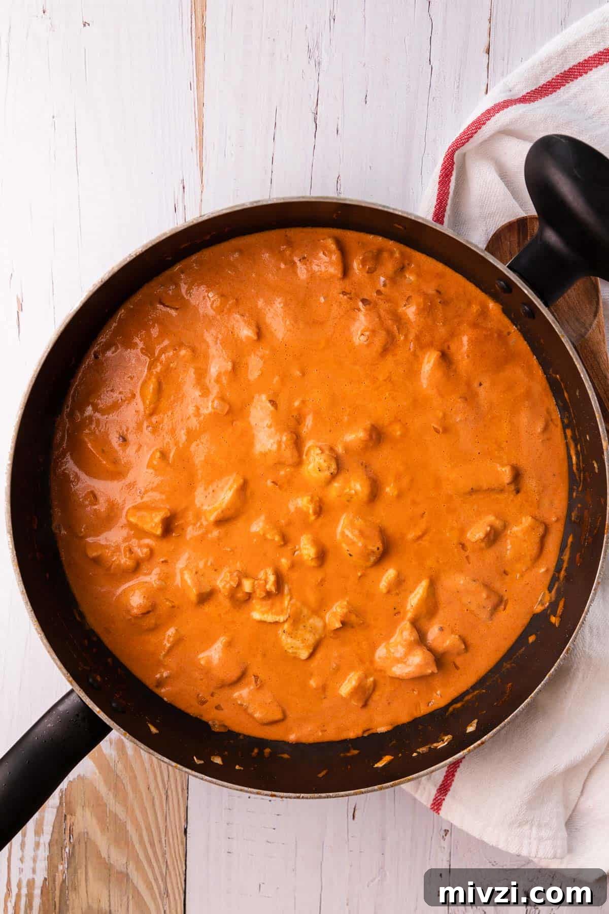 Brazilian-Style Chicken Stroganoff Recipe for Dinner 9 a skillet with cooked chicken in a tomato sauce
