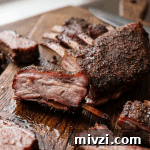 A rack of lamb ribs with one rib sliced and laid sidewise to show doneness.